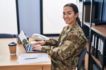 Young hispanic woman army soldier using laptop at office