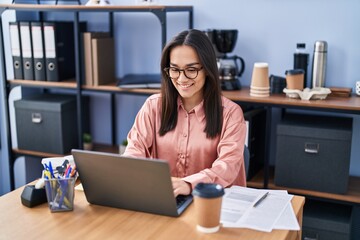 Young hispanic woman business worker using laptop working at office