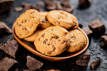Wooden plate with cookies and pieces of milk chocolate. 