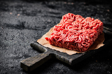 A piece of raw minced meat on a cutting board. 