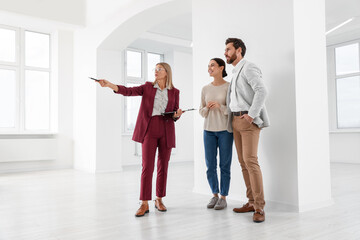 Fototapeta premium Real estate agent showing new apartment to couple