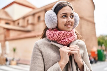 Young beautiful hispanic woman smiling confident wearing scarf and earmuff at street