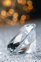 Large dazzling brilliant on shiny surface against blurred festive lights