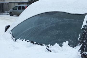 Car windshield with wiper blades cleaned from snow outdoors on winter day - obrazy, fototapety, plakaty