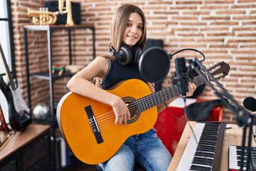 Adorable girl musician singing song playing classical guitar at music studio