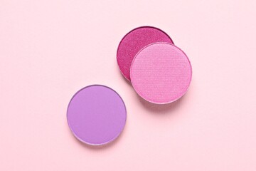 Different beautiful eye shadows on pink background, flat lay