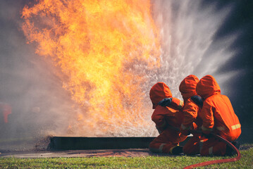 Firefighter Rescue training in fire fighting extinguisher. Firefighter fighting with flame using...