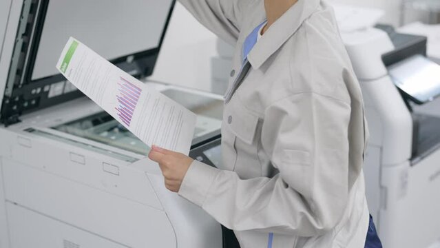 コピー機を使う女性従業員