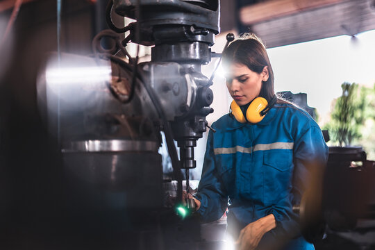 young woman smiling and working engineering in industry.Portrait of young female worker in the factory.Work at the Heavy Industry Manufacturing Facility
