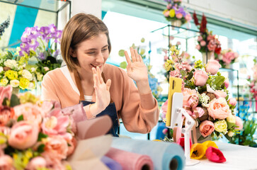 Cauasian Female Owner Of Florists Shop With Laptop Talking On Mobile Phone.Asia woman vlogger influencer or SME owner people smile work on home video camera selfie .