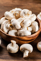 A wooden plate full of fresh mushrooms. 