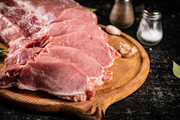 Raw pork on a spice cutting board. 