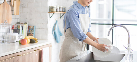 キッチンで食器を洗う人