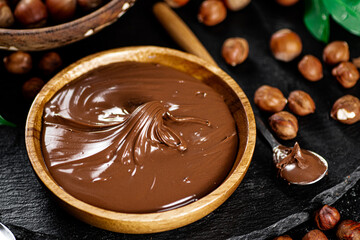 Hazelnut butter on a stone board on a plate and in a spoon. 