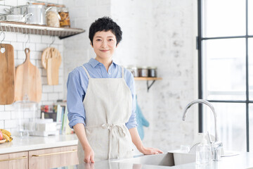 エプロンをつけてキッチンに立つ日本人女性
