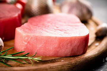 Fresh raw tuna steak with rosemary and garlic. 