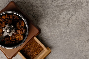High angle composition of  coffee beans and vintage coffee grinder on abstract background, space for text