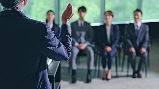 登壇する男性と聴衆　セミナー　プレゼンテーション