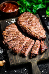 Sliced grilled steak on a cutting board.