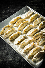 Gyoza dumplings with shrimp on a cutting board. 