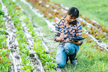 Teenage female sitting and use digital pen and tablet in farm