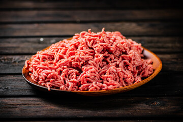 A wooden plate full of minced meat.