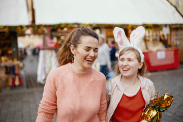happy young mother and child at fair in city