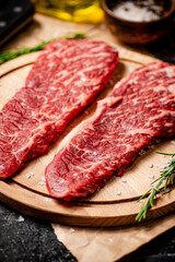 Raw steak on a wooden cutting board. 