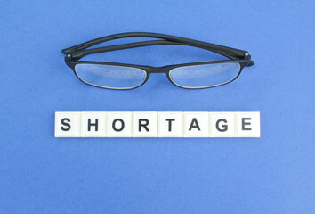 glasses with the words of the alphabet lacking. staff shortage concept. the concept of lack of...