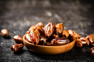 Full wooden plate with dates on the table. 