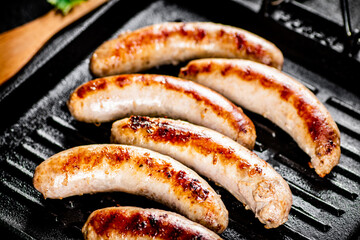 Grilled sausages in a frying pan. 