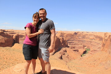 adult couple standing in front of desert river gorge utah