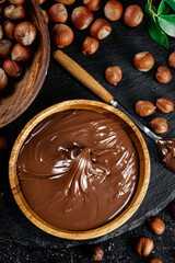 Hazelnut butter on a stone board on a plate and in a spoon. 