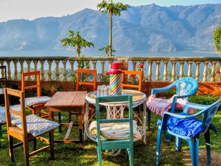 A charming rustic setting, with mismatched tables and chairs set for a morning tea break,...