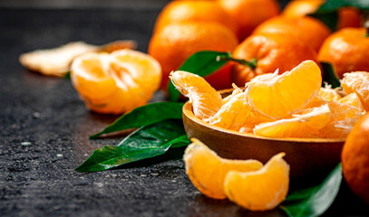 Peeled fresh tangerines. On a black background.