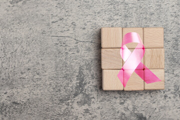 Square wooden block with pink ribbon symbol. Breast cancer concept. Copy space.