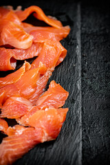 Pieces of salted salmon on a stone board. 
