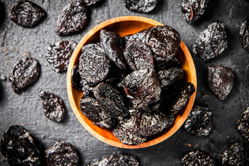 Prunes in a wooden plate on the table. 