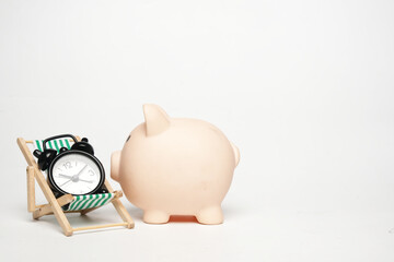 A picture of piggyback,  folding chair and alarm clock on white background. Financial planning and retirement plan concept.