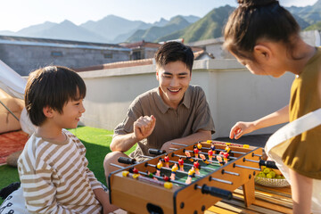 The young father and children playing outdoors table football
