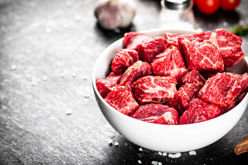 Sliced pieces of raw beef in a bowl.