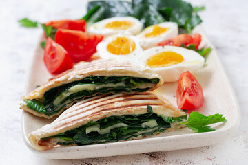 Fresh tortilla wraps with spinach and cheese on light background .  Healthy food concept. Vegetarian food.