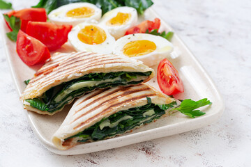 Fresh tortilla wraps with spinach and cheese on light background .  Healthy food concept. Vegetarian food.
