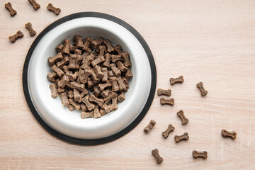 A bowl of dog food on a wooden floor.
