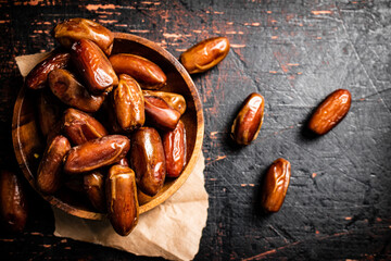 Delicious dates on a wooden plate. 