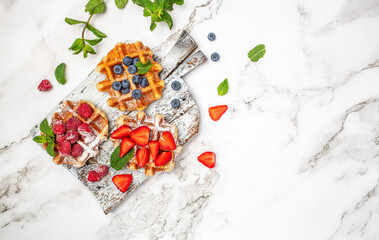 Berry Belgian Waffle with raspberries, strawberries and blueberries. Delicious sweet desert. Long banner format. top view