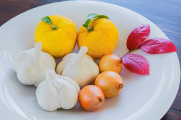 白い皿のユズとニンニクとペコロス