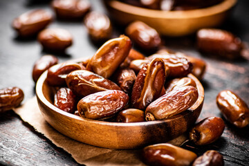 Delicious dates on a wooden plate. 