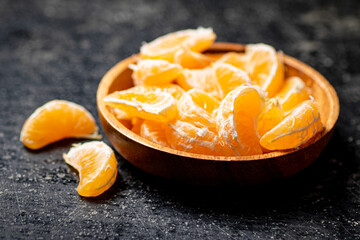 Peeled fresh tangerines. On a black background.