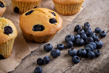 muffin with blueberries on a wooden table. fresh berries and sweet pastries on the board.